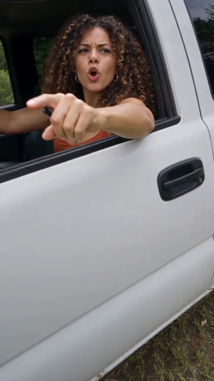 Motorista de cabelo cacheado e regata ferrugem anotando um nome