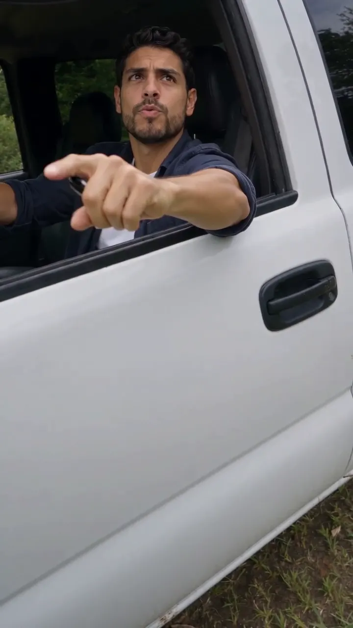 Motorista de barba e camisa azul-marinho apontando e anotando um nome